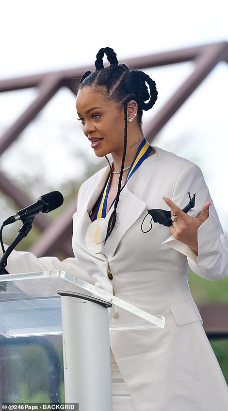 Congratulations: Rihanna looked sensational in an all-white ensemble as she accepted her insignia