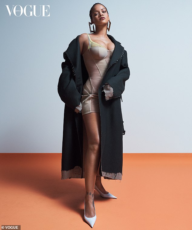 Cover star: Rihanna puts on a busty display in a nude bodysuit and long black coat as she graces the cover of Vogue Australia