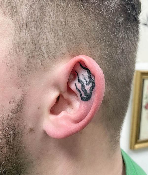 Bold black flames ear tattoo by @rhi.draws