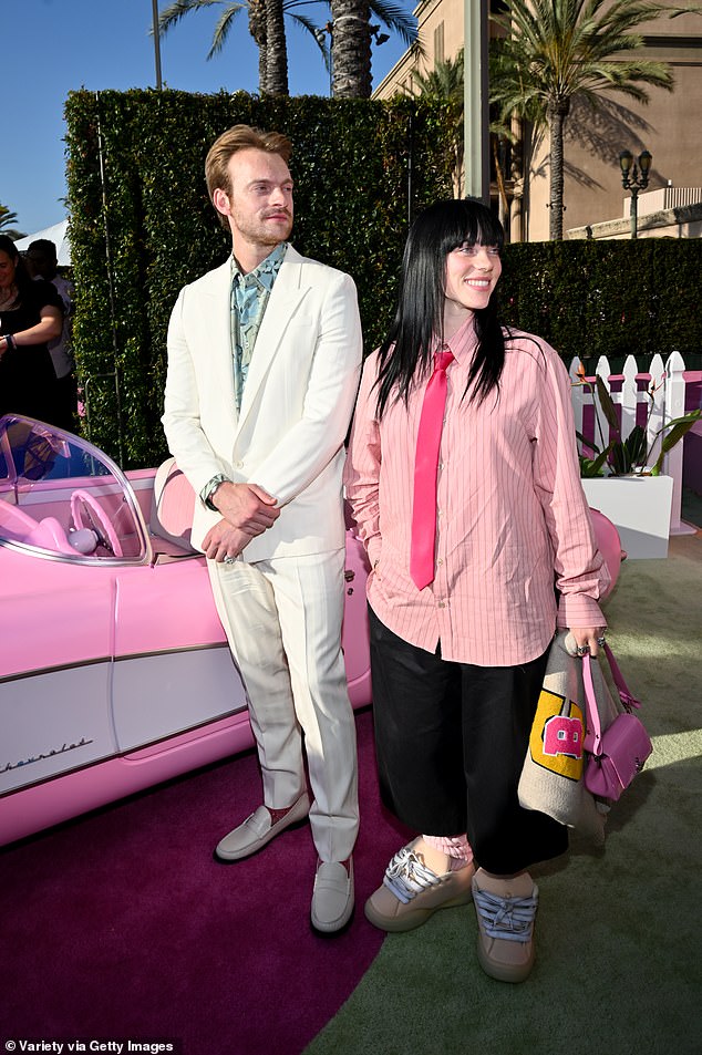 Billie Eilish shows off her unique style in black slacks with pink  pinstripe shirt and tie | Daily Mail Online