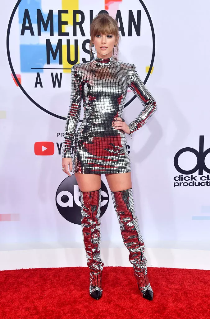 Taylor Swift wearing a disco-inspired mini dress and matching thigh high boots at the 2018 American Music Awards