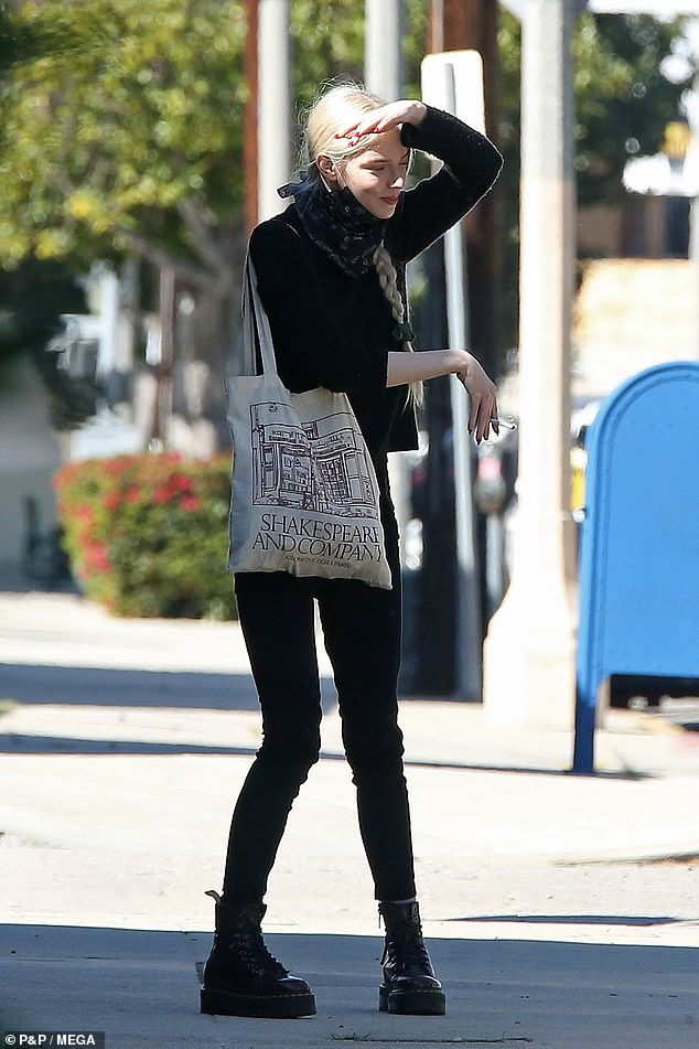 Time out: After lighting her cigarette while on the move, the actress perched on the edge of the pavement to smoke.