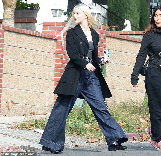 The star of The Menu - who recently put on a leggy display during an Emmys afterparty - tucked a low-cut black top into a pair of wide-legged dark blue jeans