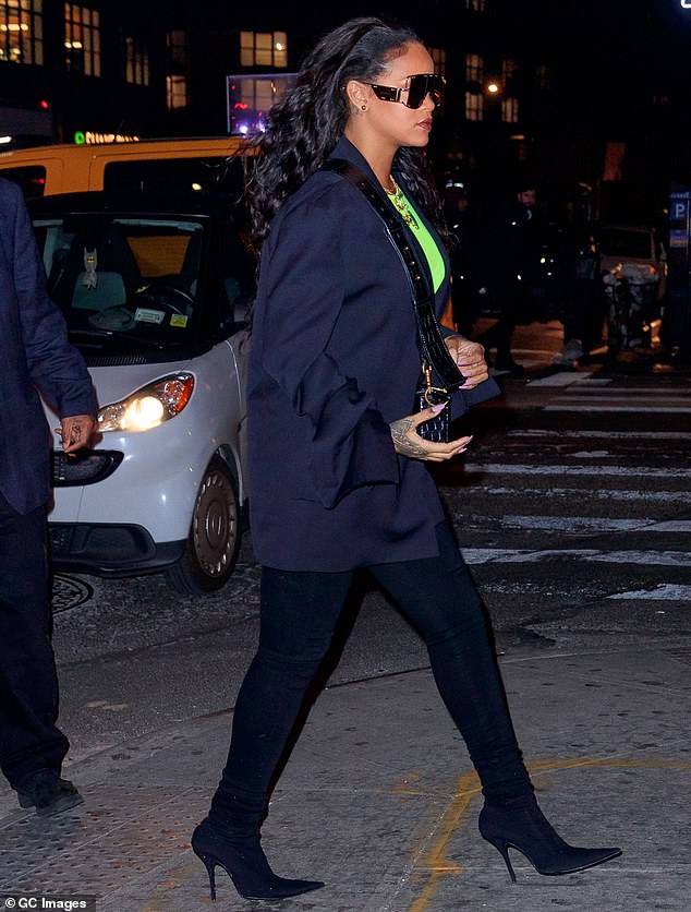 Stunner: The 30-year-old born Robyn Rihanna Fenty threw a wide-set blue blazer over an electrifying lime green top, slipping into sky-high navy stilettos