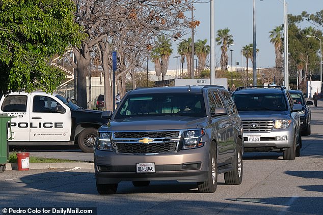 The star appeared to shield behind a curtain in a SUV as she was whisked away from LAX