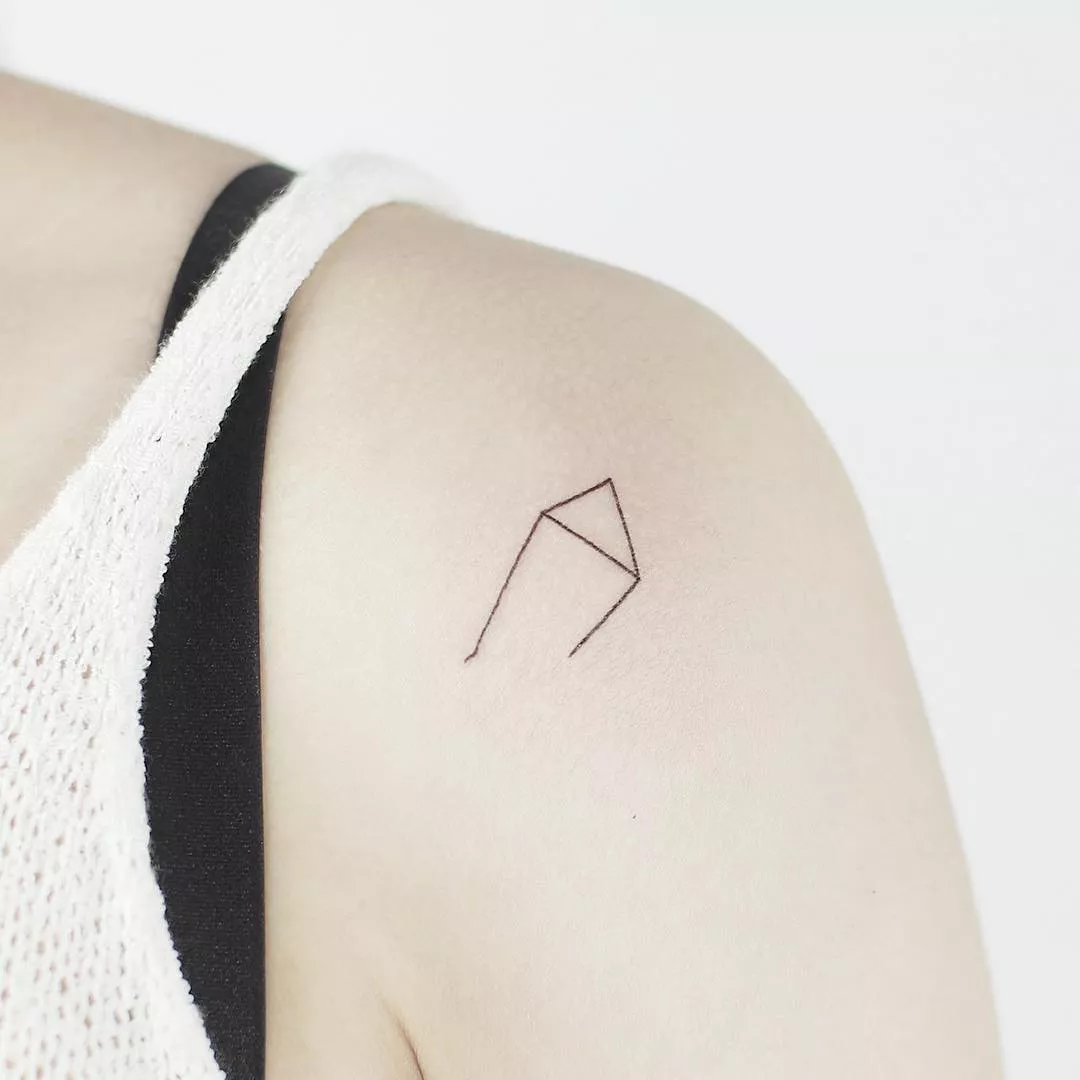 Image of a minimalistic Libra tattoo on a shoulder