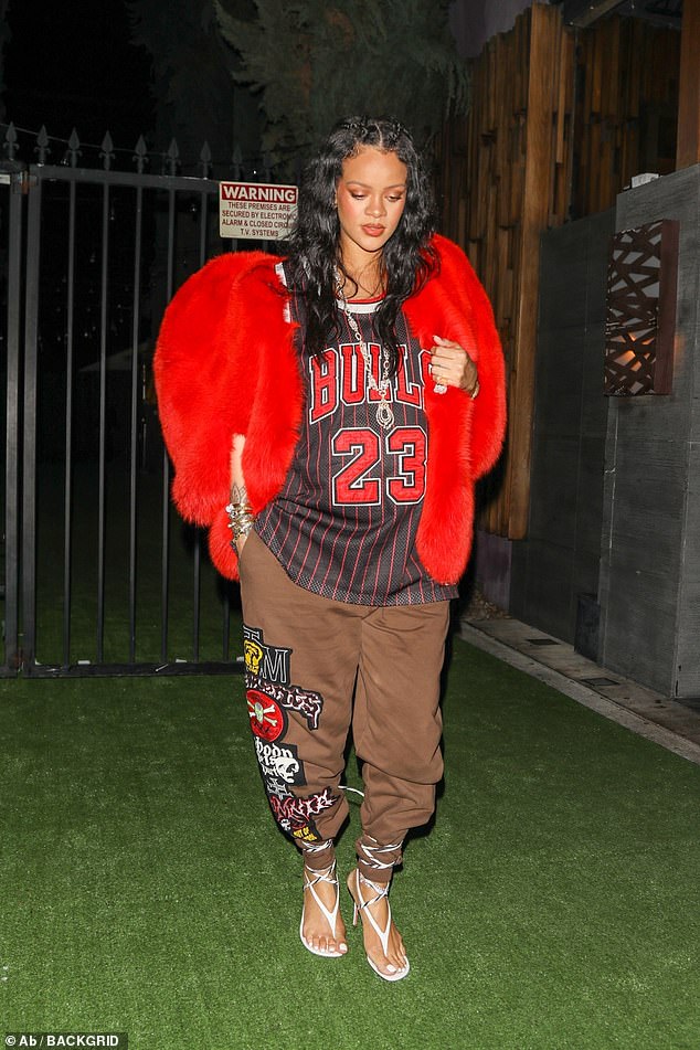 Bumping along: Rihanna reprised her $14,669 (£10,813) heart-shaped jacket from Saint Laurent to team with a Chicago Bulls jersey as she headed out for dinner at Nobu on Tuesday
