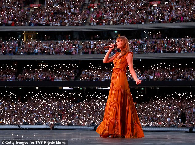 At one point in the show, Taylor put on a very elegant display in a stunning orange gown as the crowds lit up with torches behind her