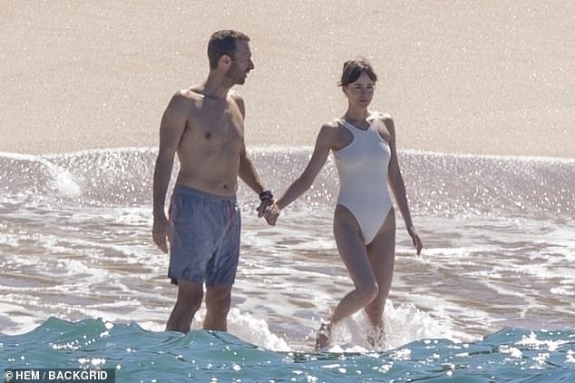 The couple held hands as they splashed around the water before returning back to shore, where the father-of-two could be seen kneeling on the sand as he gave a prayer of gratitude