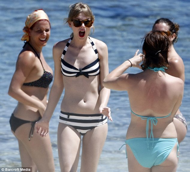 Girls' day out: Taylor made the most of the sunshine with some of her friends as they sunned themselves on the beach