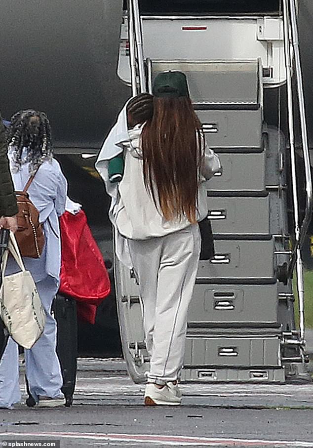 She wrapped her sleeping baby boy in a blanket as she carried him onto the plane