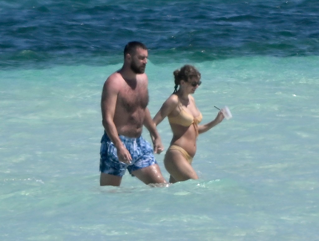 Taylor Swift and Travis Kelce hold hands in the ocean while on vacation on Harbour Island, Bahamas on Thursday, March 21, 2024. 