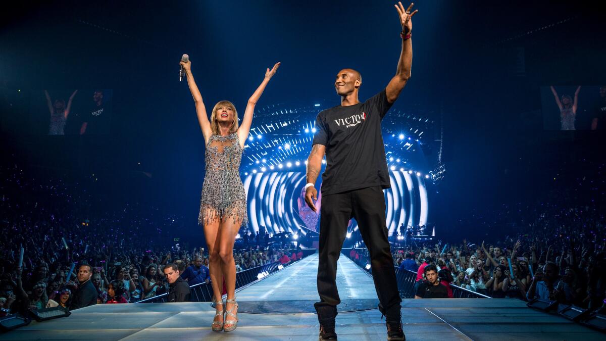 Taylor Swift welcomes Kobe Bryant to the stage during the opening night of her five concerts at Staples Center.