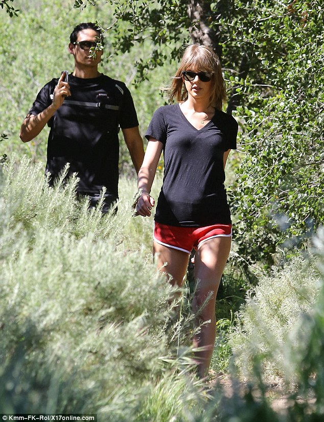 Watch those prickly bushes: The 5ft 10ins superstar singer wore a black T-shirt and a tiny pair of red shorts as she hiked 