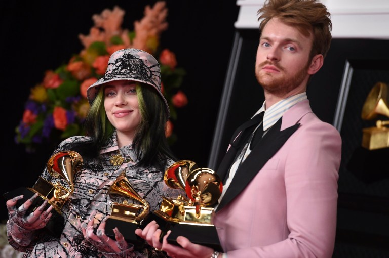 Finneas, left, and Billie Eilish pose in the press room with the awards for best song written for visual media and record of the year at the 63rd annual Grammy Awards at the Los Angeles Convention Center on Sunday, March 14, 2021. (Photo by Jordan Strauss/Invision/AP)