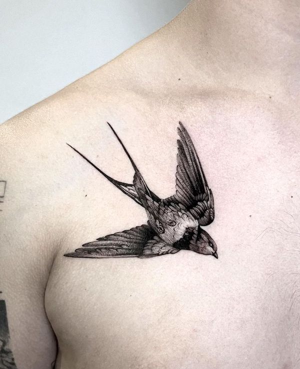 Black swallow shoulder tattoo for men by @chara_tattooer