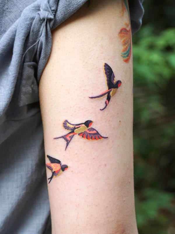 Cute colored swallows on the arm by @pagwa