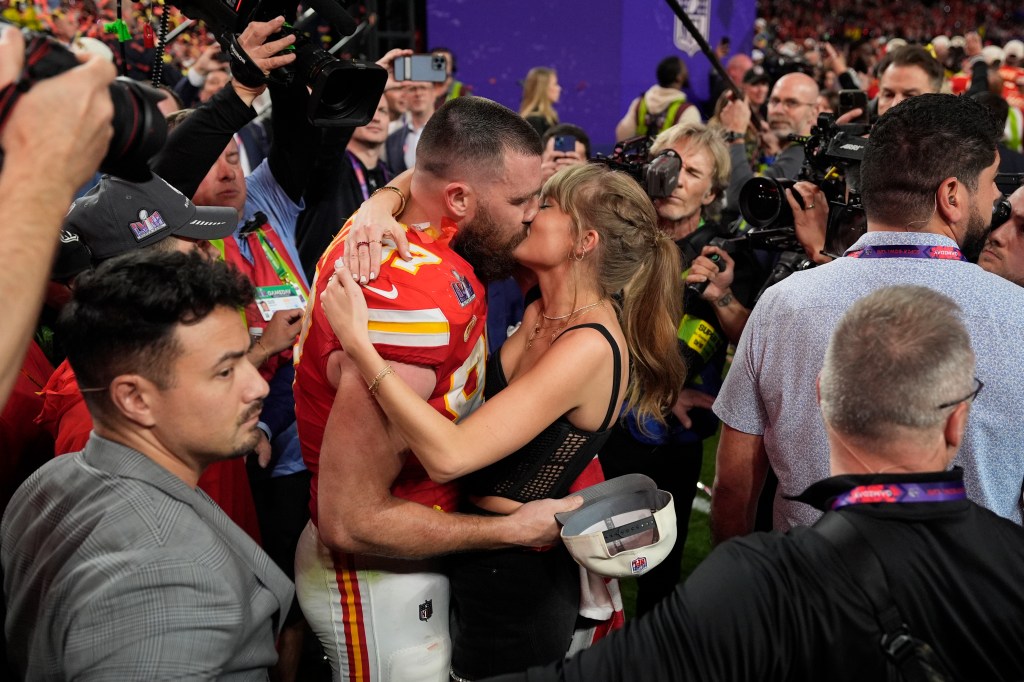 Travis Kelce (87) kisses Taylor Swift 