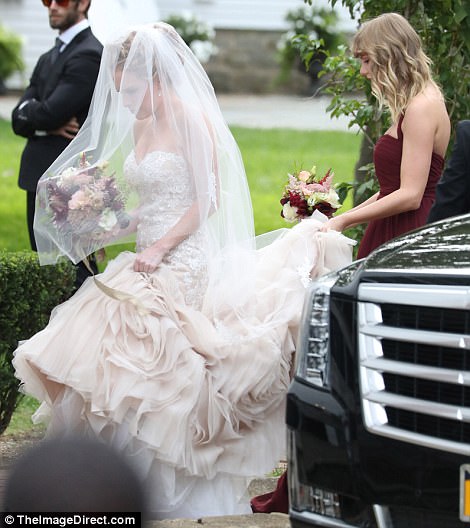 Let's do this! Taylor certainly fulfilled her bridesmaid duties as she happily carried Abigail's train for her, as she headed inside