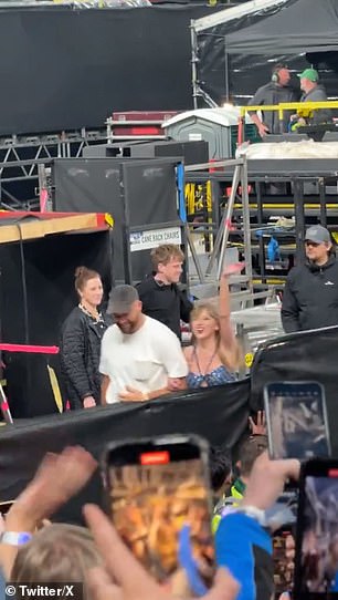 Taylor waves at the crowd as she and Travis walk arm in arm off the stage in Dublin