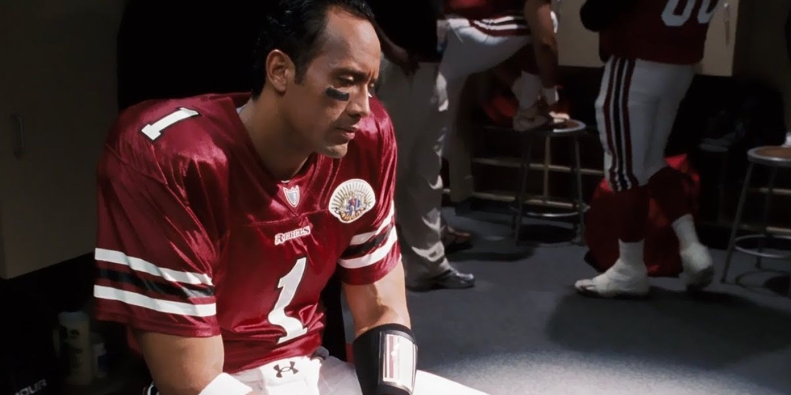 Dwayne Johnson looking dejected in a football locker room in The Game Plan