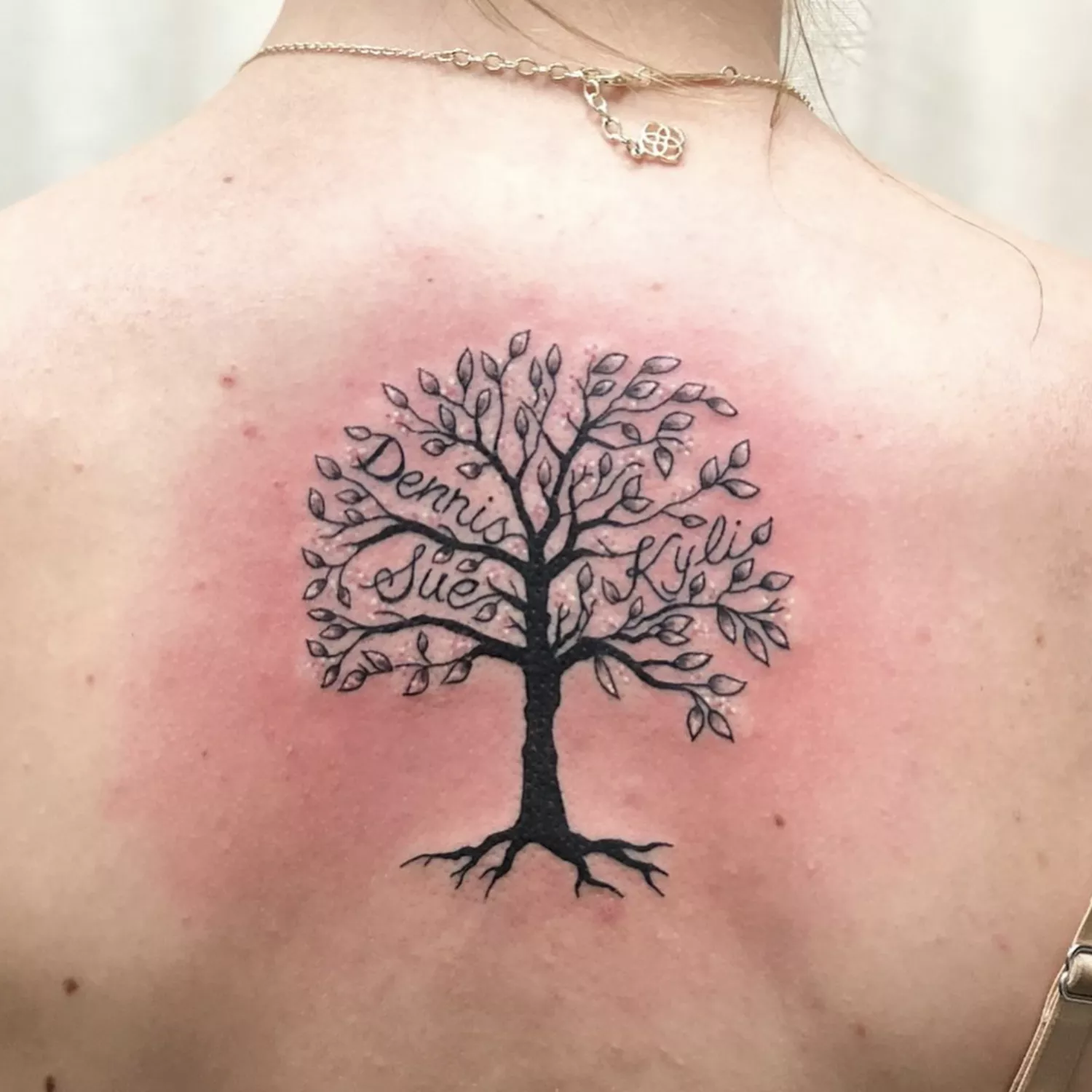 Family tee tattoo on back