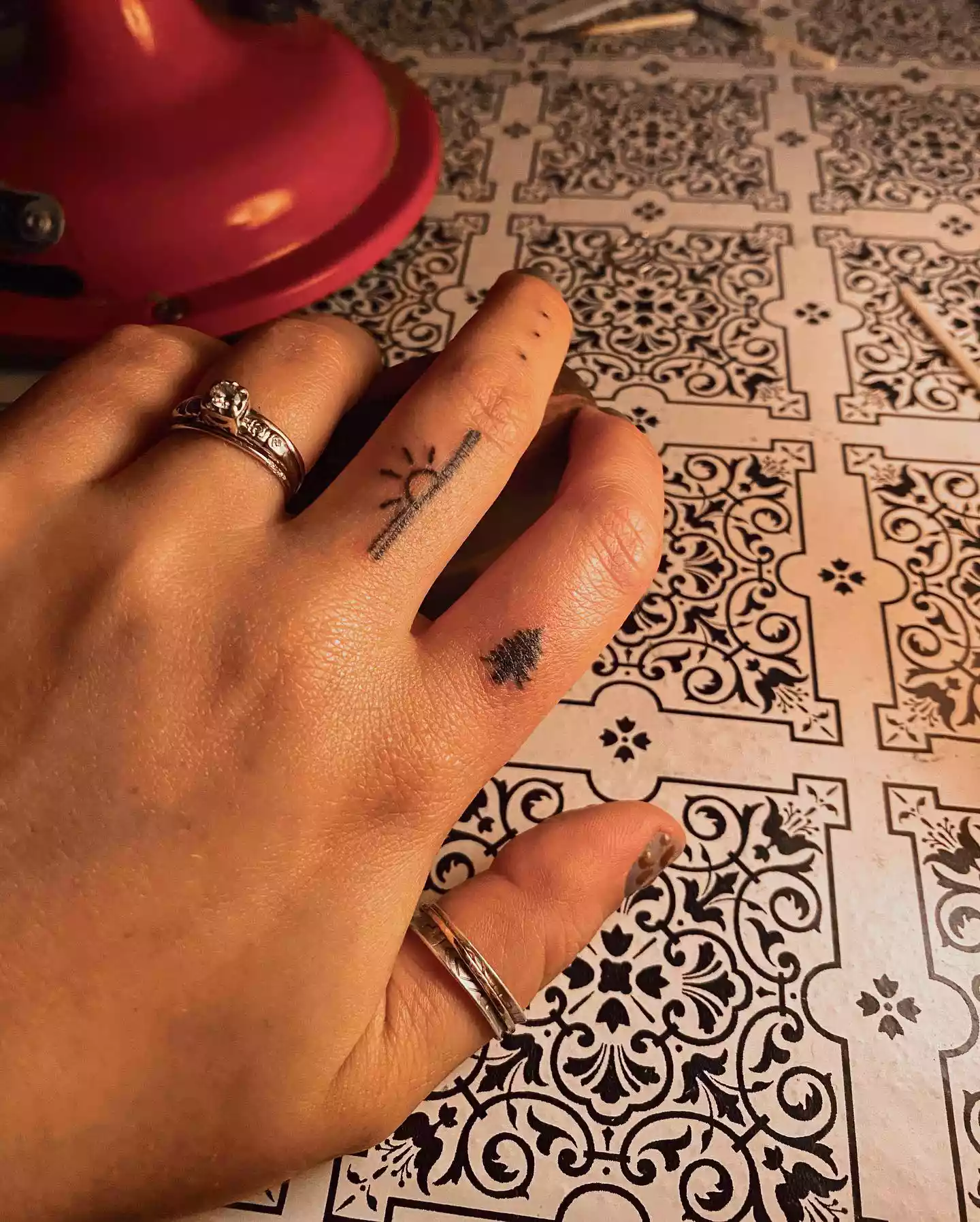 Close up of a finger with a pine tree tattoo