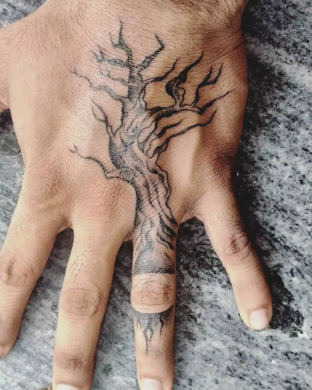 Close up of a hand with a tree tattoo