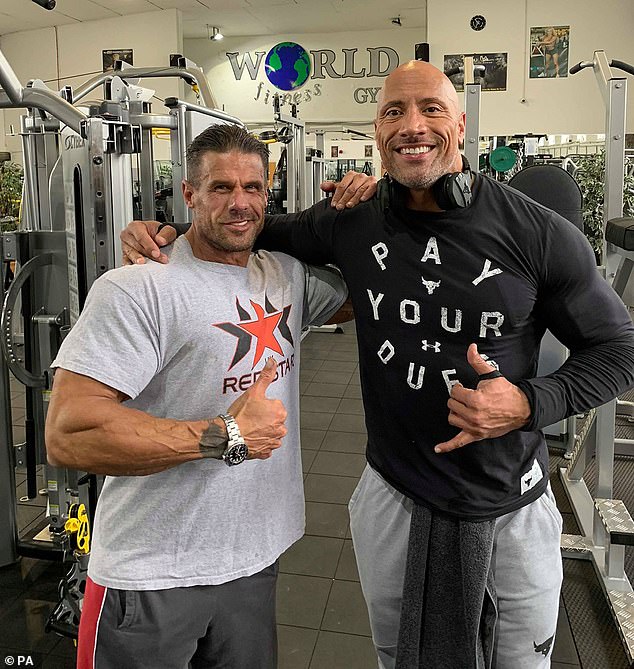 Special guest: The 46-year-old Hollywood heavyweight happily posed with the owners of the World Fitness Gym as he took break from filming Hobbs and Shaw