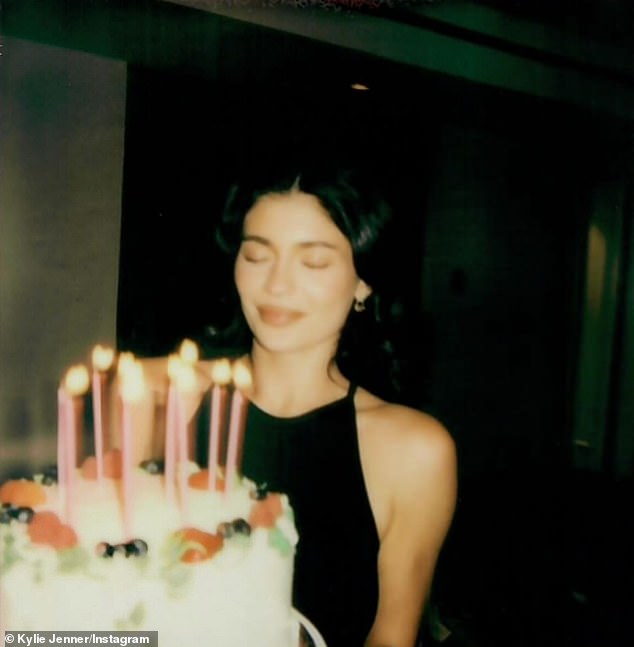 In a series of polaroid snaps, Kylie glammed up in a halter-styled black dress as she held a cake topped with sugary icing and lit candles in front of her