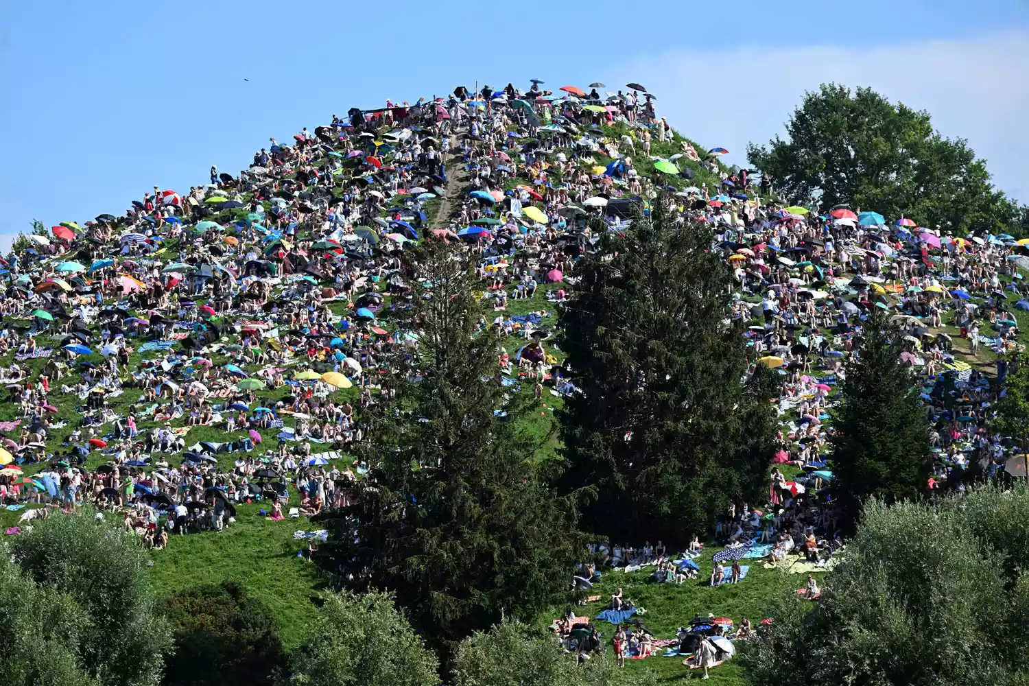 Bavaria, Munich: Fans sit on the Olympiaberg in the Olympiapark and wait in the sunshine for the Taylor Swift concert to begin. Taylor Swift's first of two concerts in Munich as part of her "The Eras Tour" is taking place there today.