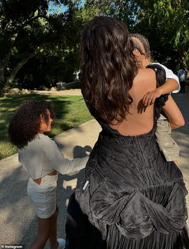 The 27-year-old makeup mogul  wore a billowing black dress as she doted on her two kids in one post