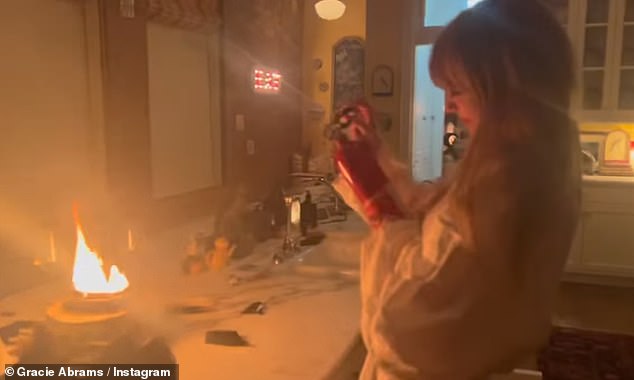 Taylor Swift was filmed brandishing a fire extinguisher in new video of her putting out a blaze in her New York City apartment - shared by collaborator Gracie Abrams