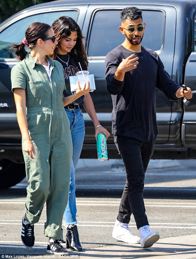 Summer fun: Selena's dark tresses tumbled in relaxed waves across her shoulders as she wore a necklace with a cross on it